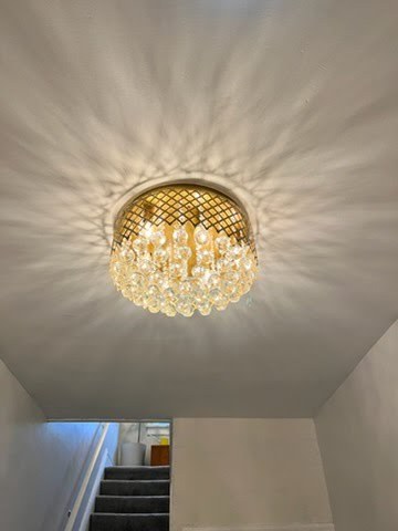 After: a new crystal ceiling fixture lighting the hallway