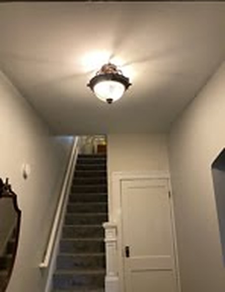 Before: an old hallway ceiling light at the bottom of the stairs