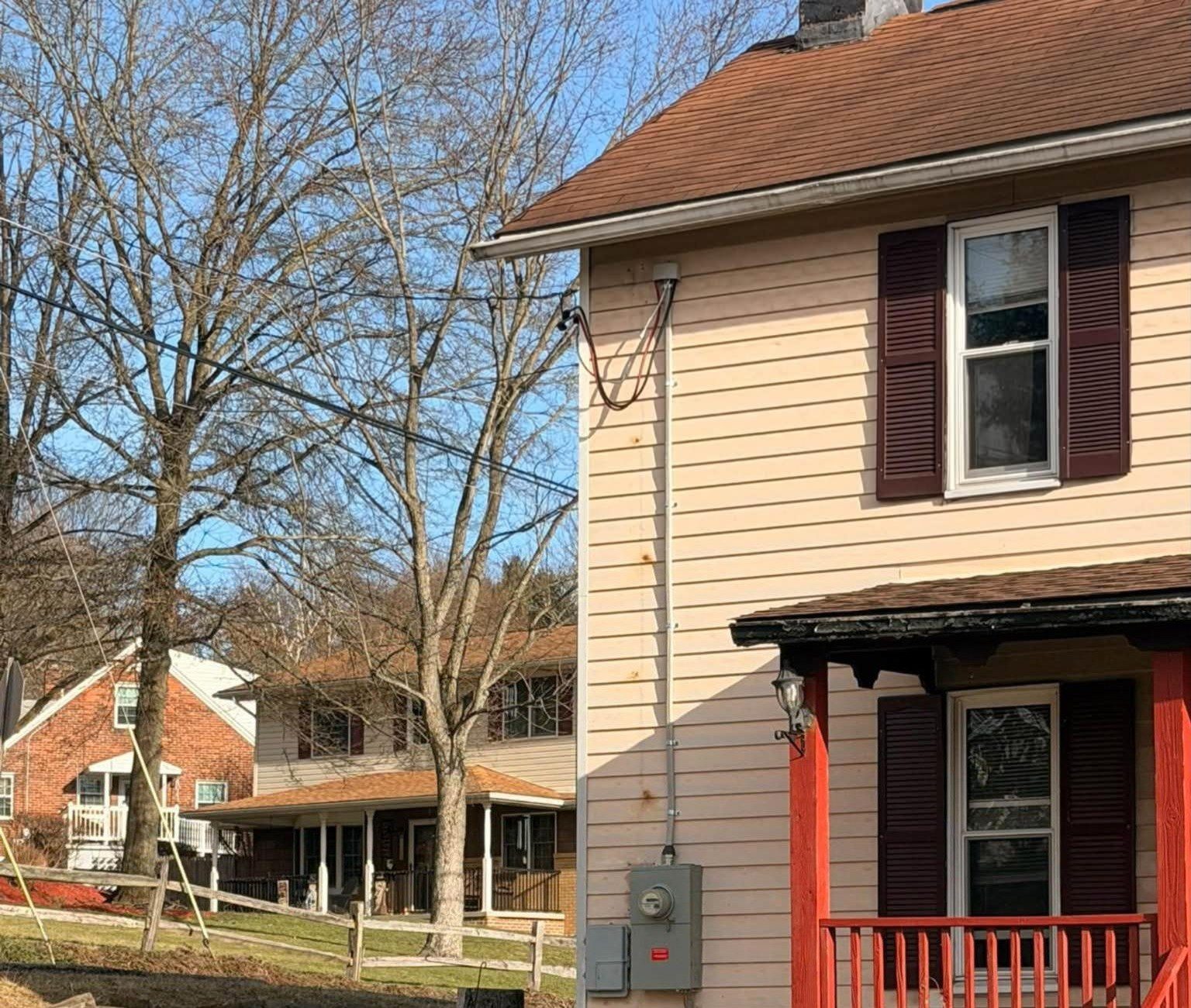 A new weatherhead, meter base and conduit on the siding of a house