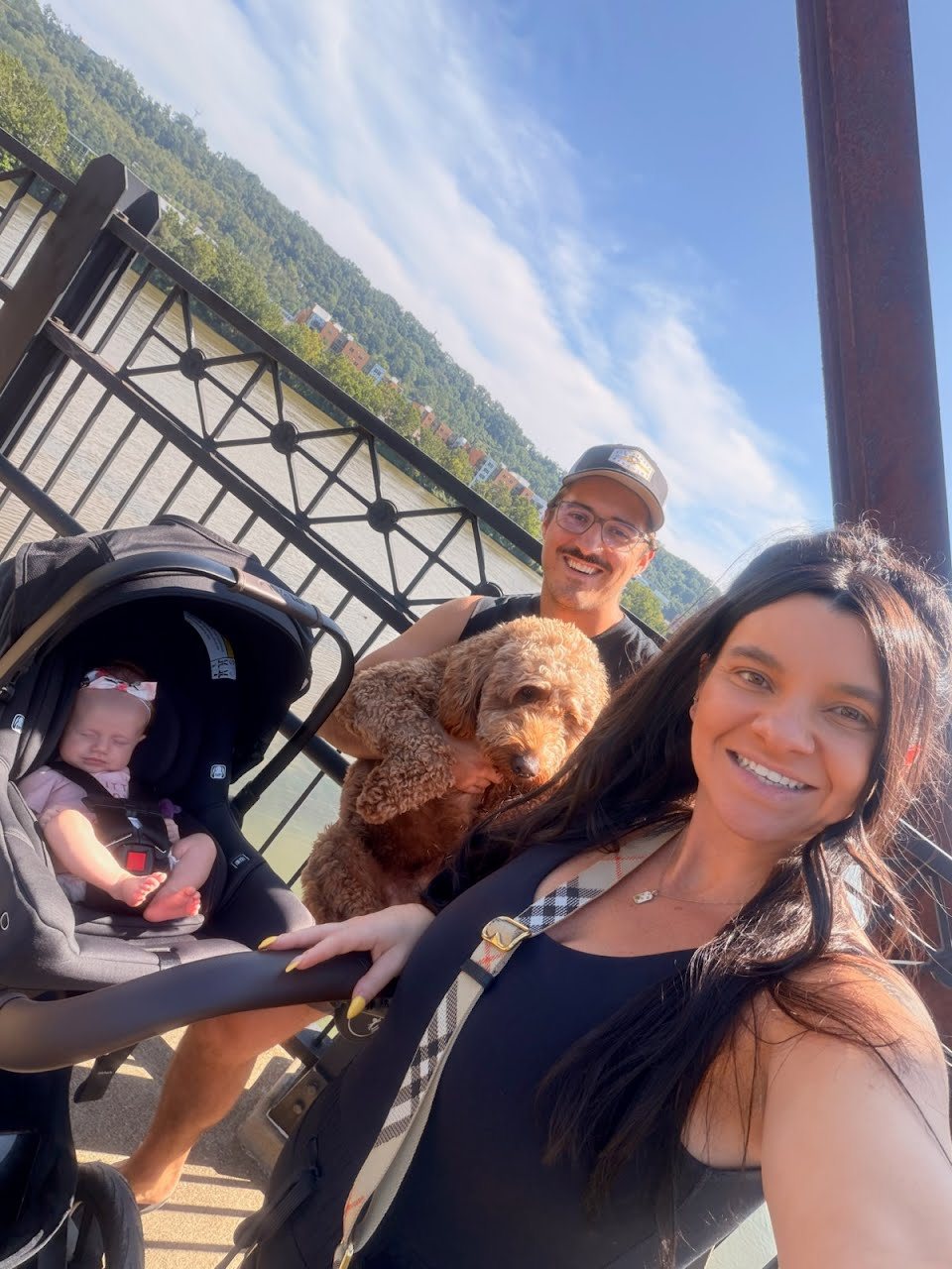 Matt with his wife Lex, their daughter Bella and their dog Theo on a bridge over the river